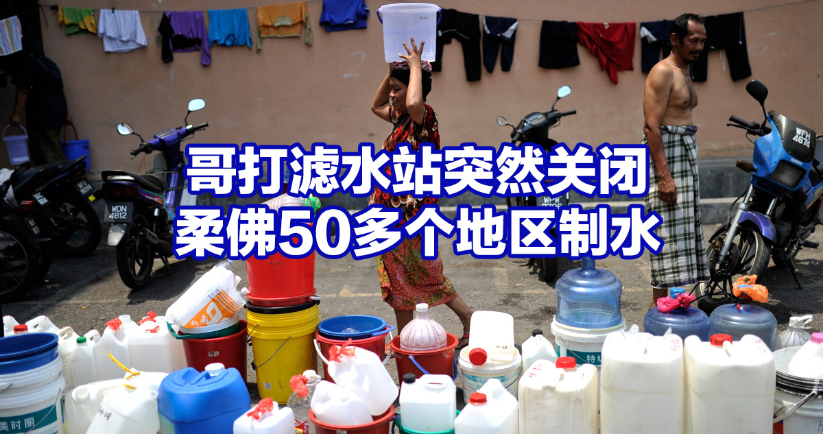A woman carries a bucket of water past containers during water disruption at Taman Ehsan Impian in Balakong on February 25, 2014. The Malaysian Insider/Najjua Zulkefli