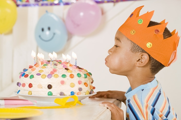 Boy blowing out candles on birthday cake