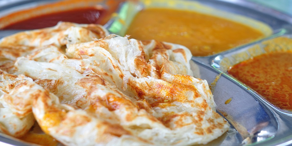 Roti canai flat bread Indian food made from wheat flour dough. Famous malaysian dish Roti canai and curry.