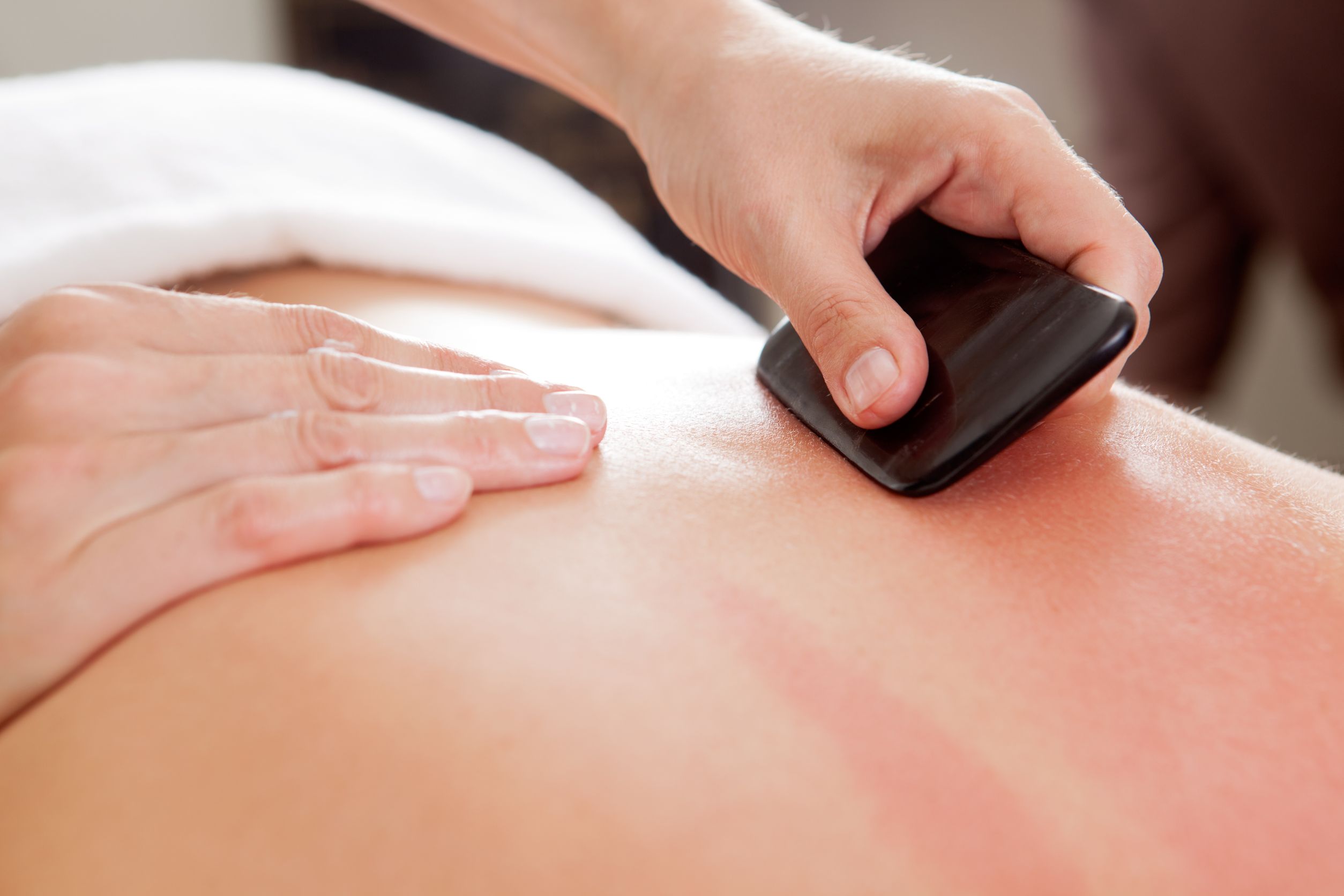 10989206 - large bone scraper tool being used ruing a guasha acupuncture treatment