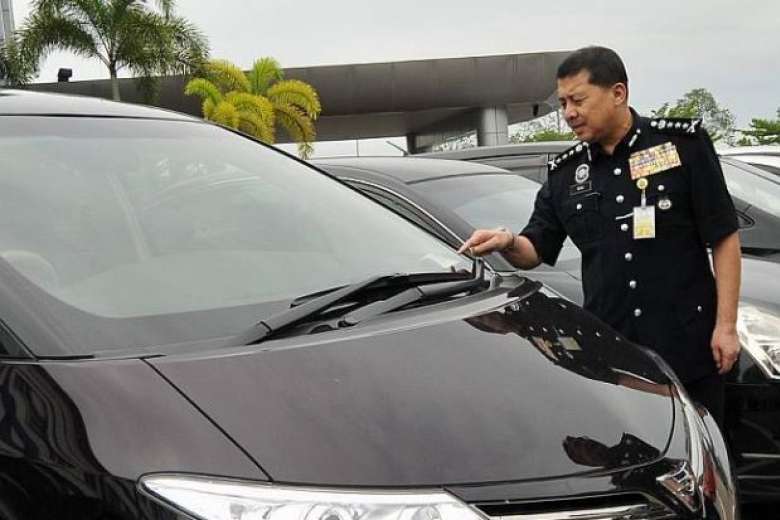 Johor police chief Wan Ahmad Najmuddin Mohd looking at stolen vehicles at the Kulai police headquarters.PHOTO: THE STAR/ASIA NEWS NETWORK